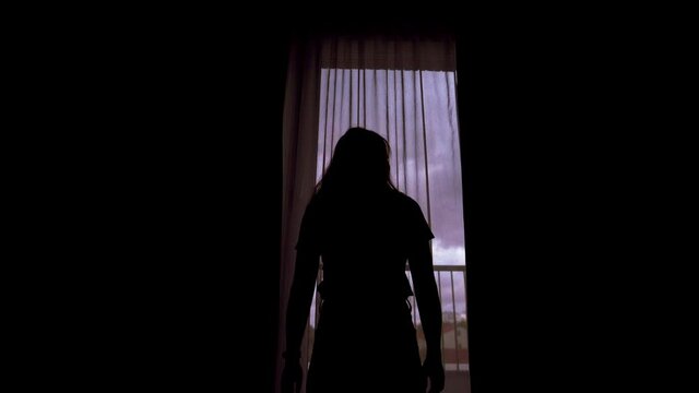 Silhouette Of Young Woman Opens Window Curtains
