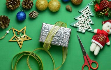Christmas preparations, gifts and decorations on green background.