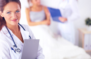 Smiling female doctor with a folder in uniform standing at hosp