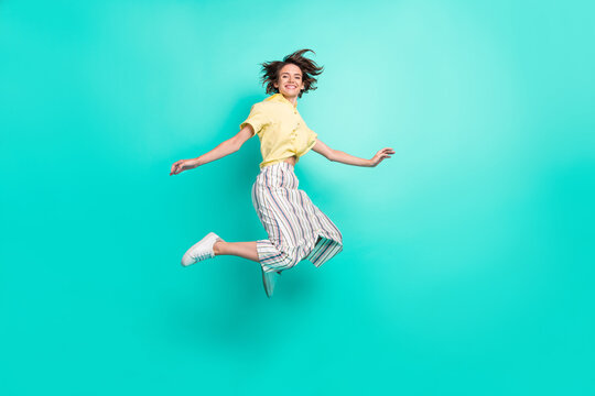 Full size profile side photo of young girl happy positive smile have fun jump up isolated over teal color background