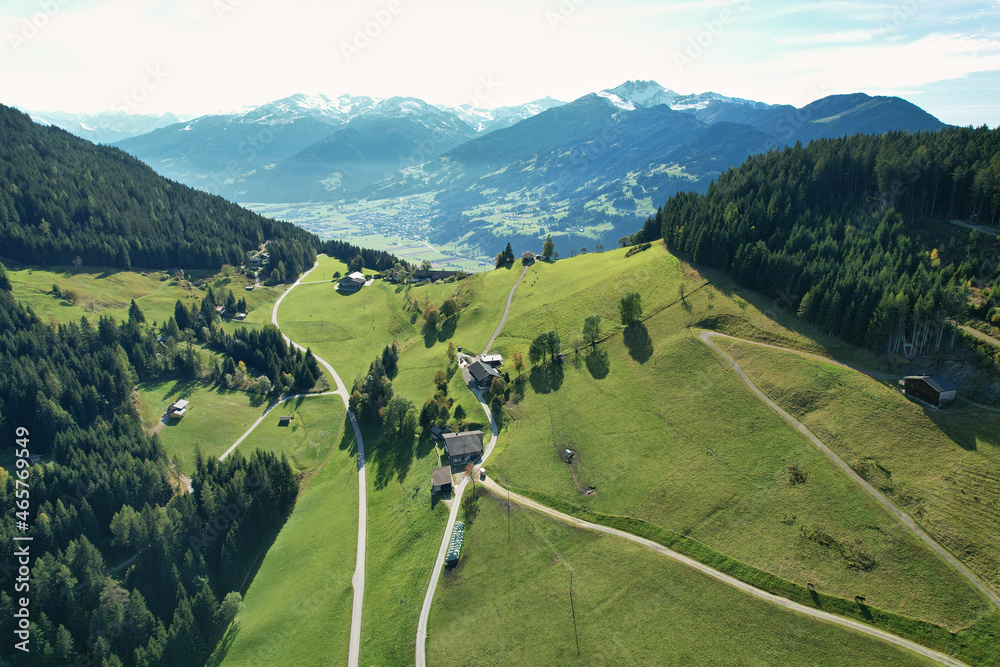 Sticker Drone view of an alpine farm with meadows and blue sky