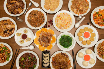 Chinese dishes and appetizers viewed from the top, steamed gyozas, dim sum, orange duck, almonds,...