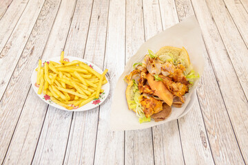 Kebab menu with chicken and lamb sandwich with lettuce and onion and side of French fries