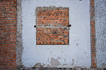 A wall with a walled-up window opening.