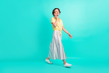 Full body profile side photo of young girl wear long skirt go speak cellphone isolated over...