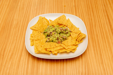 Nachos with cheese, guacamole and baked chili con carne are a Mexican classic, a tasty chili con carne and cheese gratin with the fresh hints of guacamole, cilantro, bell peppers and sour cream