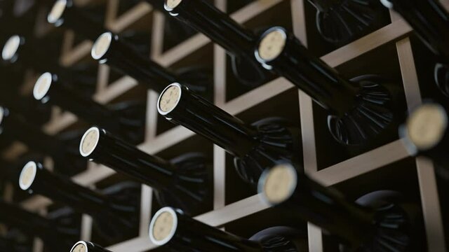 Looping animation of wine bottles ordered on wooden shelves in dark wine-cellar.
