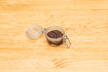 Chocolate granny cake inside airtight glass container on light wooden table