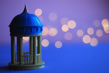 gazebo for lovers with a blue dome on a pink-purple background with bokeh on the left