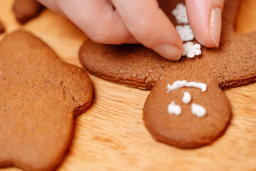 Gingerbread cookies are decorated with sweet icing snowflakes buttons. Sweet pastries for the new year.