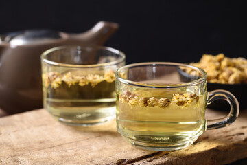 Chrysanthemum flower hot tea in a cup glass and teapot with dry flowers, Healthy Herbal drink