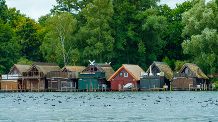 Scenic view of boathouses on a lake with ducks