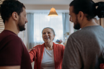 Sons congratulate mom on the holiday. Men visiting their beloved mother on a holiday