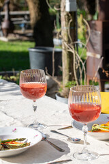 Dinner in a summer garden with vegetarian food. Rose wine on a table in a summer garden setting. roasted vegetables. Carrot, asparagus, zucchini and paprika.