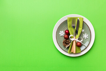 Christmas table place setting with christmas decor and plates, kine, fork and spoon. Christmas holiday background. Top view with copy space