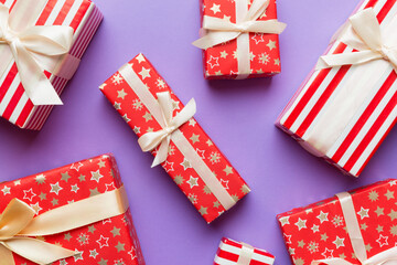 Fototapeta premium A lot of Christmas gift boxes in colored paper decorated on table, Top view close up. Many present New Year gift