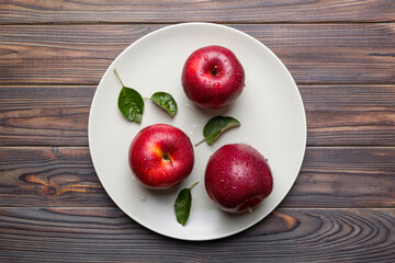 juicy red apples in a bowl or plate on the table top view. Copy space