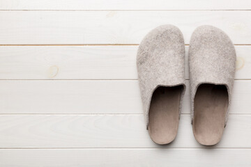 Warm winter women woolen slippers on the floor. Copy space for text