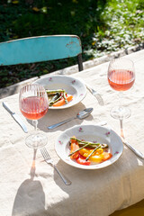 Dinner in a summer garden with vegetarian food. Rose wine and vegetarian food. Roasted vegetables.