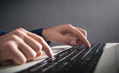 Male hands typing on computer keyboard.