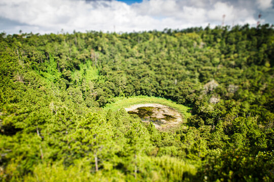 View of Trou aux Cerfs volcano crater in Mauritius surrounded by green vegetation and cloudy sky