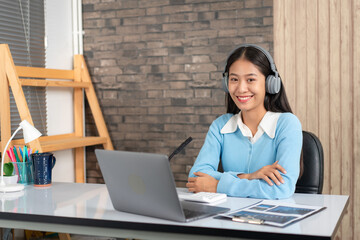 Female tutor wearing headset, using laptop and though camera to teaching new lesson by video...