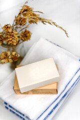 Laundry soap and a stack of linen towels on the table. Accessories for house cleaning and cleanliness.