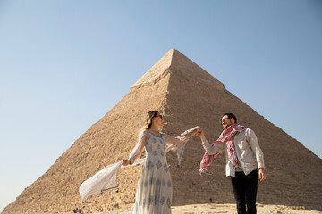 traveling couple dancing at pyramids of giza - obrazy, fototapety, plakaty