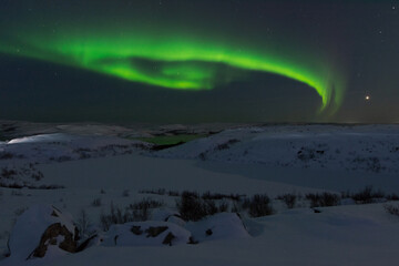 At night in winter, the tundra and the aurora borealis.