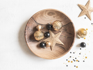 Christmas or New Year background - wooden plate with various Christmas balls and gold star on white background.