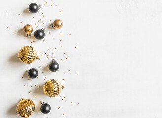 Happy new year and Merry Christmas, gold stars glitter and black and gold christmas balls on white textured background.