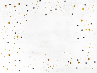 Golden confetti and black sequins frame on white background.