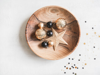Christmas or New Year background - wooden plate with various Christmas balls and gold star on white background.