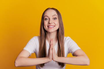 Obraz premium Photo of young cheerful girl hands together wait wish glad want isolated over yellow color background