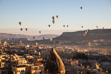 colorful hot air balloons rising over Cappadocia canyon