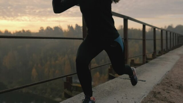 Runner woman is stretching legs with lunge hamstring stretch exercise leg stretches. Fitness female athlete is doing a warm-up before her strength training cardio workout.