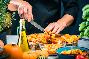 Chef cutting fresh and delicious pumkin and vegetables for cooking soup