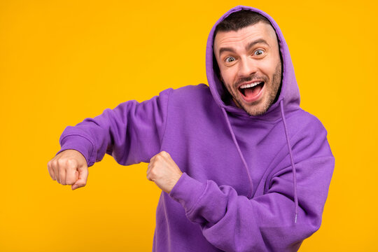 Portrait of attractive carefree cheerful guy dancing having fun rest isolated over vivid yellow color background