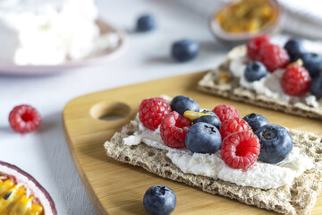Healthy breakfast. Sandwiches made of crispy bread with cottage cheese, raspberries, blueberries and passion fruit. Healthy Eating. Slimming. A healthy snack.