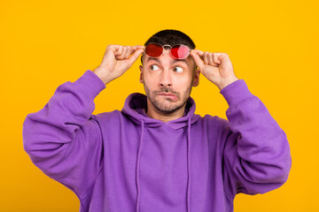 Photo portrait young man wearing sunglass looking copyspace afraid isolated vibrant yellow color background