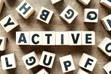 Alphabet letter block in word active with another block on wood background