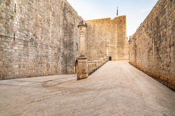 Entrance to the old city of Dubrovnik after Pilar gate. Small ancient street with stairs and old city walls. UNESCO heritage.