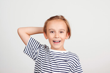 Smiling boy posing at studio. Face expression. Portrait of funny boy. Kid having fun and laughing.
