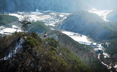 Snow-covered mountains and cable cars.