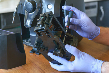 A repairman repairs a broken coffee maker