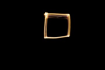 Square shape drawn with yellow light. Light painting photo.