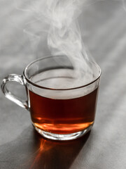 Hot steaming tea in a transparent cup. Cinnamon.