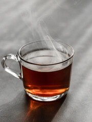 Hot steaming tea in a transparent cup. Cinnamon.