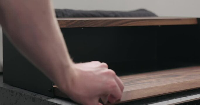 Slow motion man hand check walnut wood breadbox