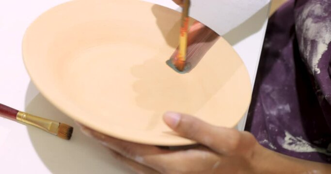 Pottery artist, workshop, painting clay bowl. Creative craft. Ceramic studio.